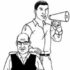 Someone stands behind a wheelchair user with a megaphone