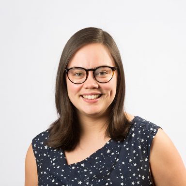 headshot of Hannah Reynolds who has shoulder length dark hair and glasses. headshot of Hannah Reynolds who has shoulder length dark hair and glasses.