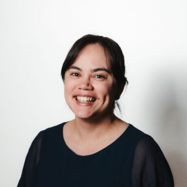 Hannah is smiling at the camera. She is wearing a navy coloured blouse. Hannah is smiling at the camera. She is wearing a navy coloured blouse.