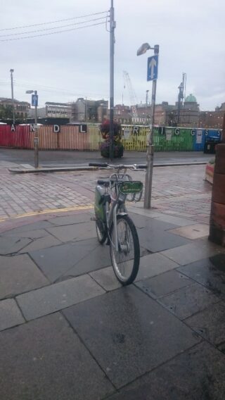 cycle parked in the middle of a pavement.