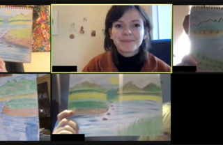 Picture shows woman with dark hair smiling, surrounded by pictures that people have drawn.