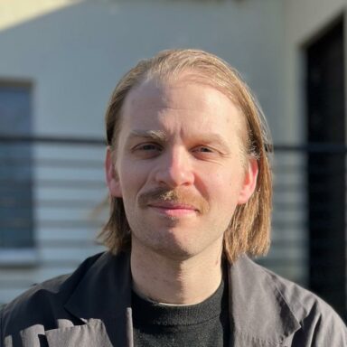 Photo of Lewis Watson. He has chin-length hair and a moustache. Photo of Lewis Watson. He has chin-length hair and a moustache.